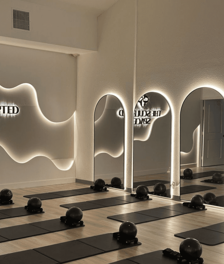 Priestor Pilates štúdia s podložkami pripravenými na lekciu.